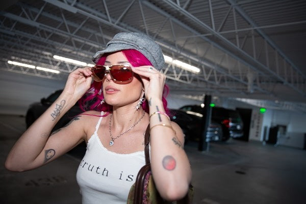 Halsey wearing the Ariel Taub Meadow butterfly earrings in silver with a white tank top that says "truth is"