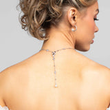 Model wearing the Palmer crystal and pearl lariat necklace in the back paired with the Prim hoop earrings