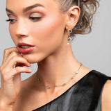 Model wearing a short gold crystal choker necklace paired with a multi-circle crystal and pearl drop earrings
