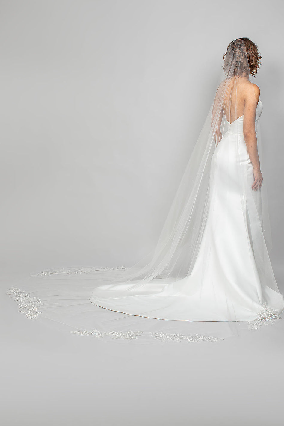 A modern cascading cathedral length wedding veil with sequin lace rose appliques placed along the train of the veil for the perfect shimmer to your bridal look.