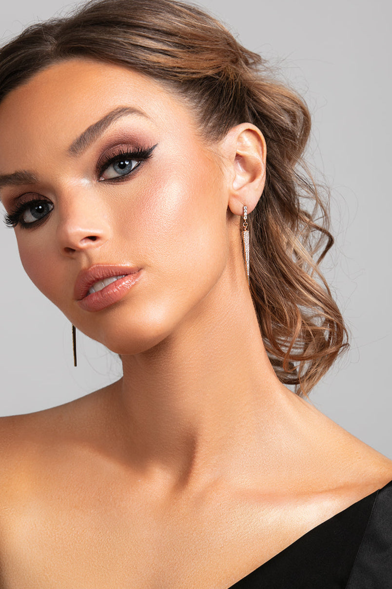 Model wearing the Sloane earrings which are a sleek long cz pave crystal spike earrings in gold.