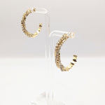 Side view of the Sparkle CZ hoop earrings in gold on earring stands.