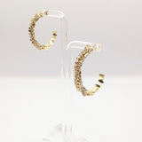 Side view of the Sparkle CZ hoop earrings in gold on earring stands.