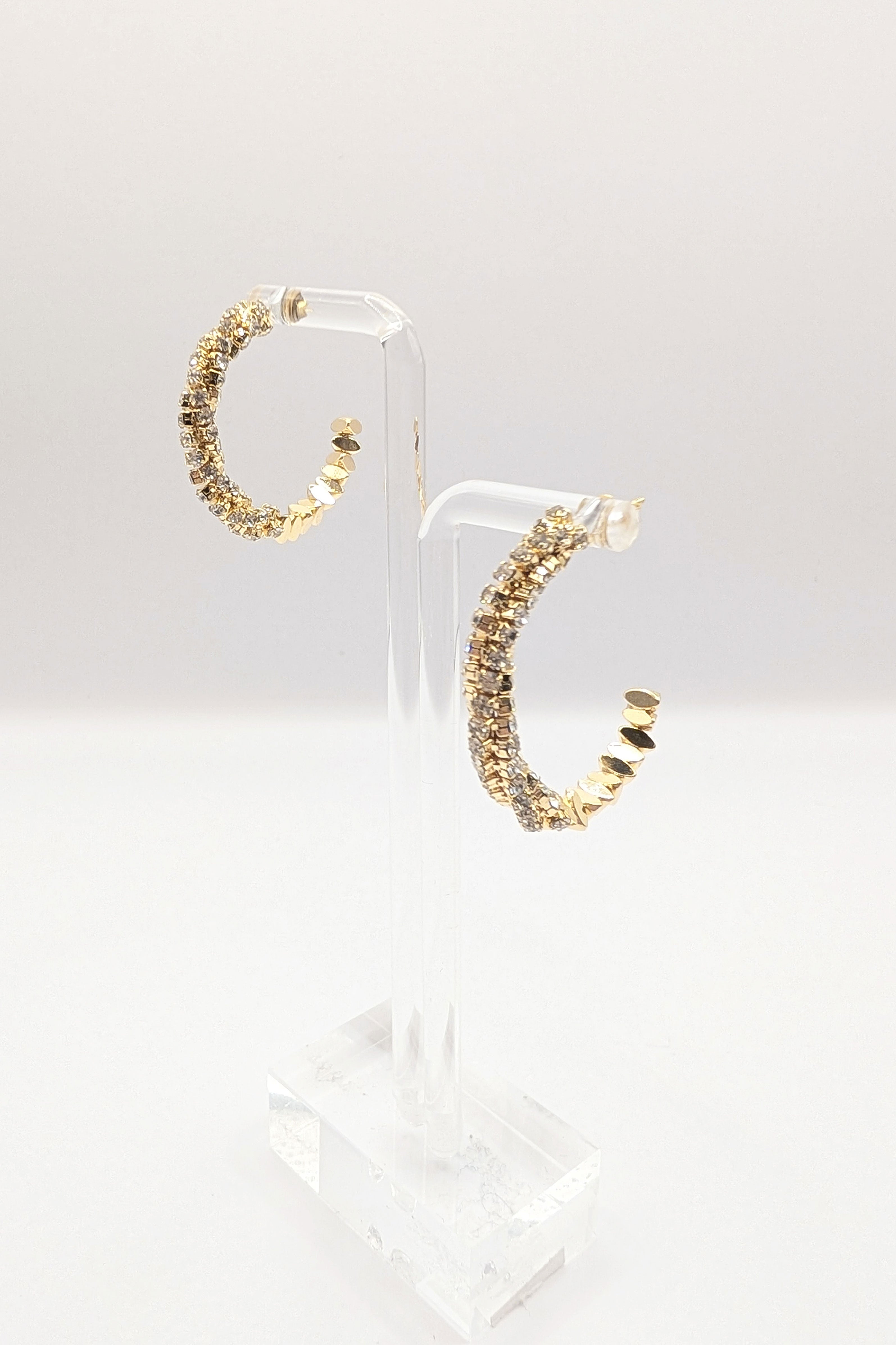 Side view of the Sparkle CZ hoop earrings in gold on earring stands.