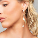 Model wearing Taylor shimmer twist pearl drop earrings in gold by Ariel Taub