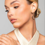 Model wearing Toni gold and silver interlocking earrings by Ariel Taub