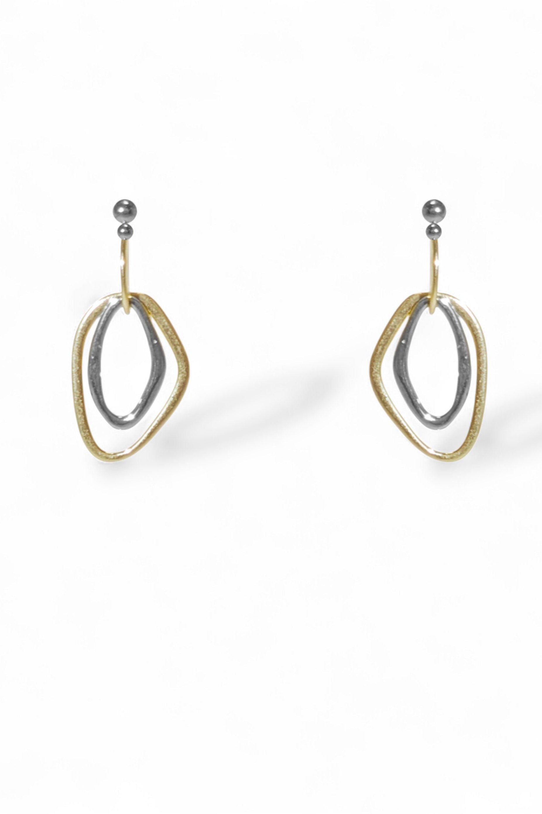 Pair of gold and silver earrings on a white background