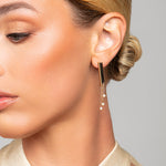 Model wearing Tracy gold Austrian pearl drop earrings by Ariel Taub