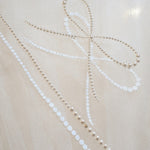 A detail shot of the Austrian pearl detail on the Reign cathedral length wedding veil.