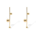 Sawyer drop earrings in gold, featuring a vertical bar with three polished gold spheres in a modern, minimalist design.