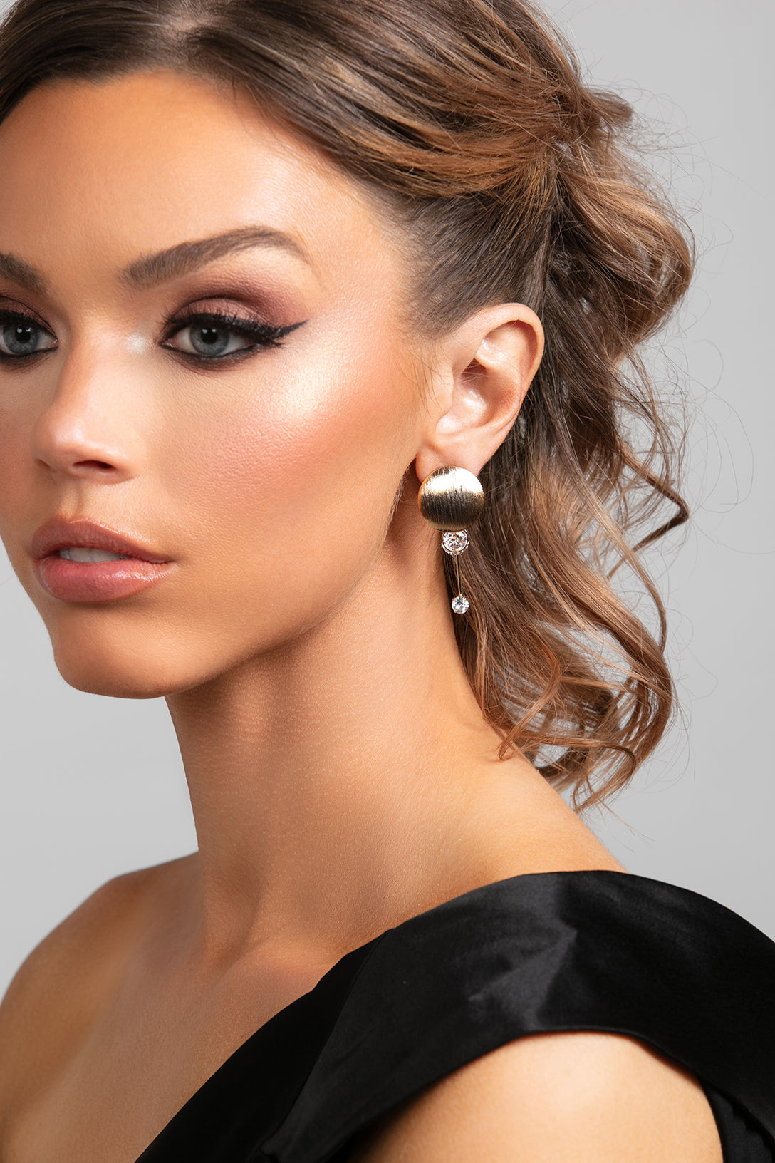Stacey gold drop earrings with brushed metal discs and CZ crystals on model