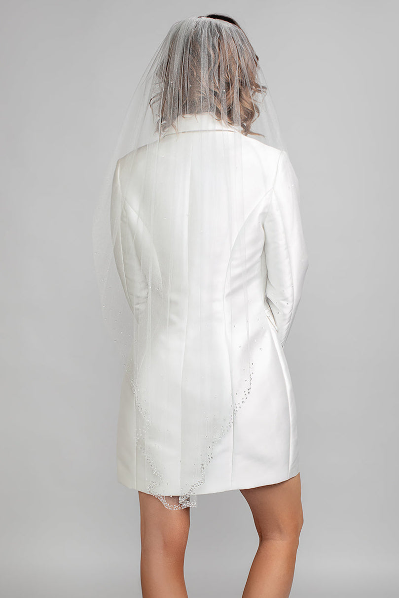 Back view of the Symphony veil with a soft cascade silhouette and sparkling crystals throughout, styled with a modern Andrea Osei BRIDE Renee blazer dress.