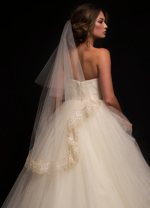 Model wearing a two tier fingertip length veil with French Chantilly scallop lace trim along the bottom tier