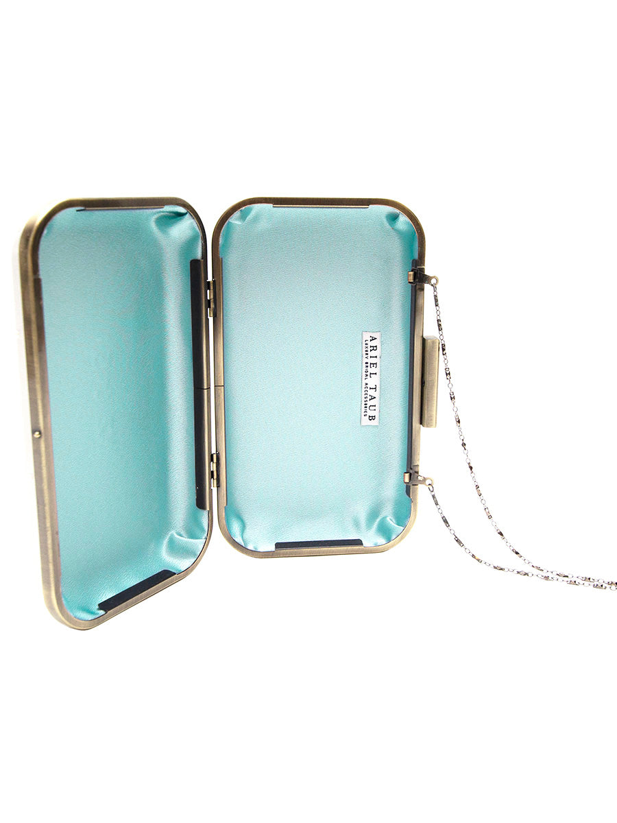 Open clutch with light blue interior and gold frame on a white background