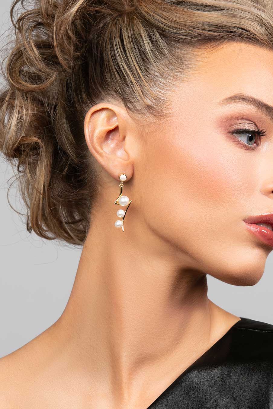 Model wearing pearl drop earrings in a lightning bold shape in silver