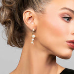 Model wearing pearl drop earrings in a lightning bold shape in silver