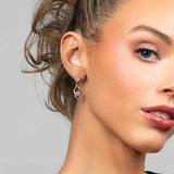 Model wearing the Perry pink cubic zirconia crystal drop earrings in gold