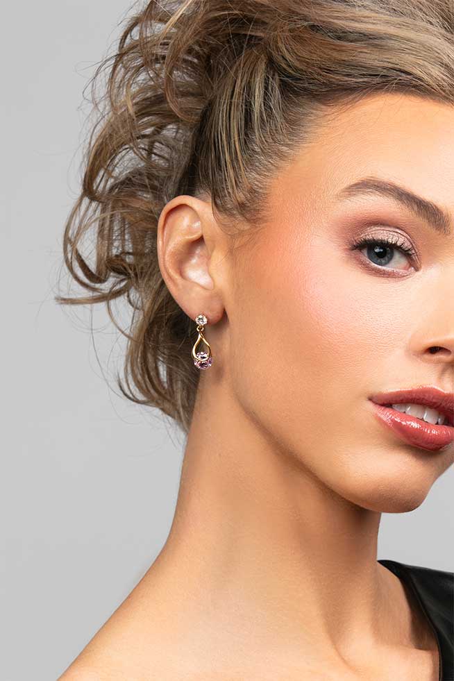 Model wearing the Perry pink cubic zirconia crystal drop earrings in gold