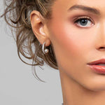 Model wearing the Prim hoop earrings which are made with CZ crystals and has a floating pearl in the back
