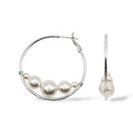 Rhodium-plated large hoop earrings featuring Austrian pearls at the bottom for a modern floating effect.