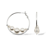 Rhodium-plated large hoop earrings featuring Austrian pearls at the bottom for a modern floating effect.