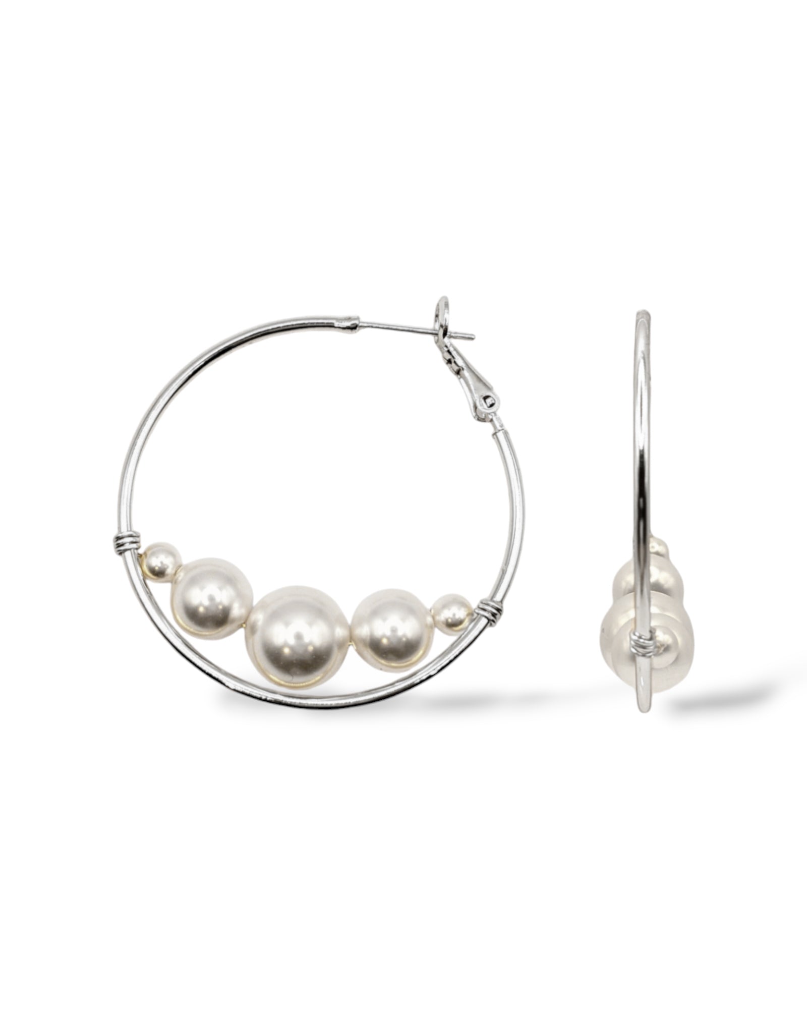 Rhodium-plated large hoop earrings featuring Austrian pearls at the bottom for a modern floating effect.