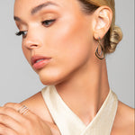 Model wearing Toni gold and silver interlocking earrings by Ariel Taub