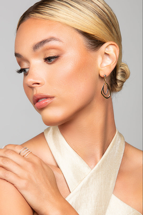 Model wearing Toni gold and silver interlocking earrings by Ariel Taub