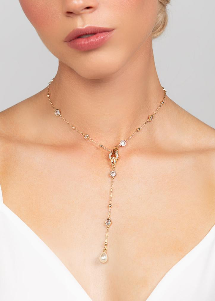 Gold Palmer lariat necklace worn by Katy Perry featuring a sleek and modern crystal chain with a detachable pearl pendant designed to add a touch of elegance to any outfit, perfect for bridal and everyday wear.