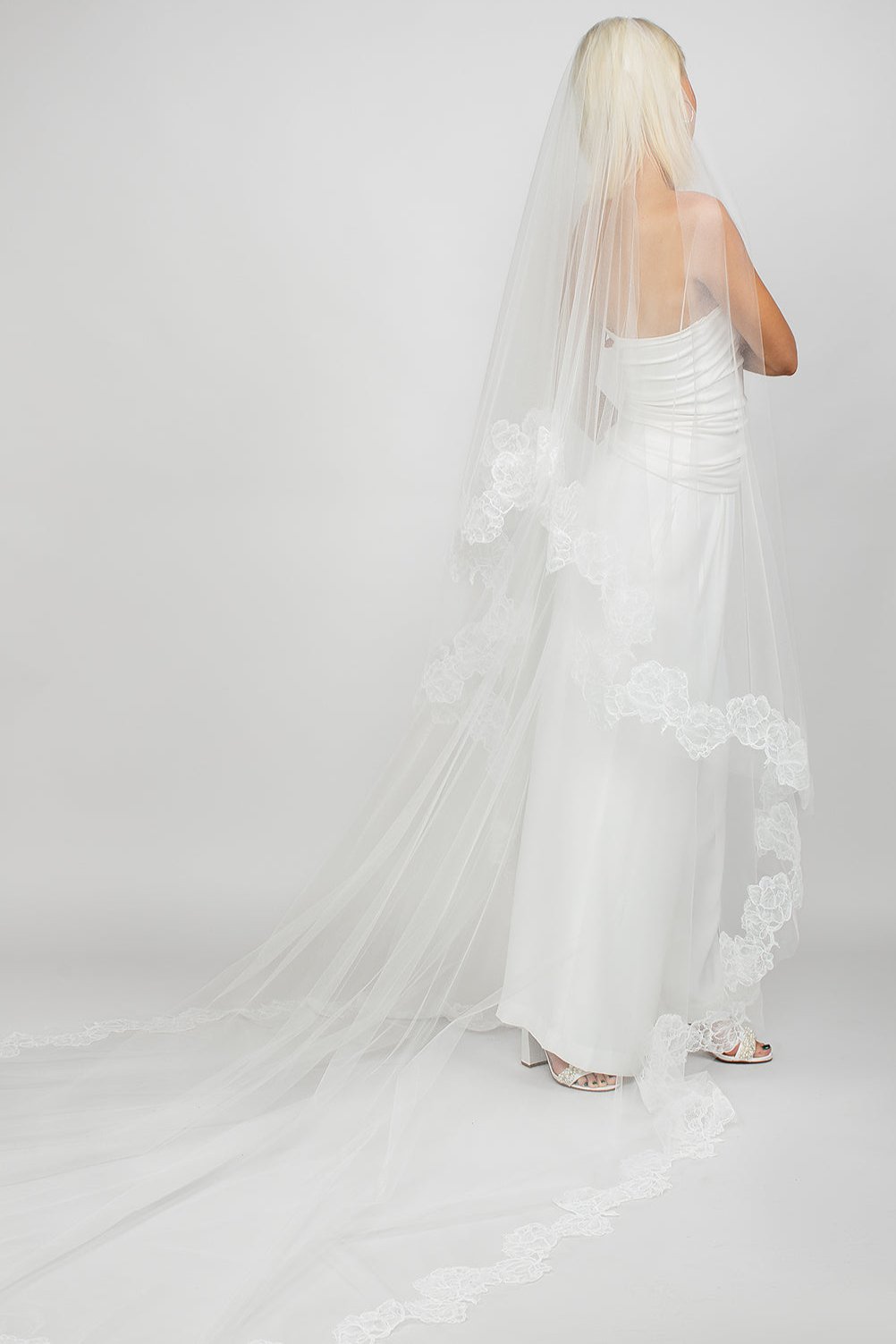 Two-tier circular cathedral-length veil with corded rose lace trimming the entire border, available in cool white and light ivory. This image shows the back view of the veil with the blusher pulled back.