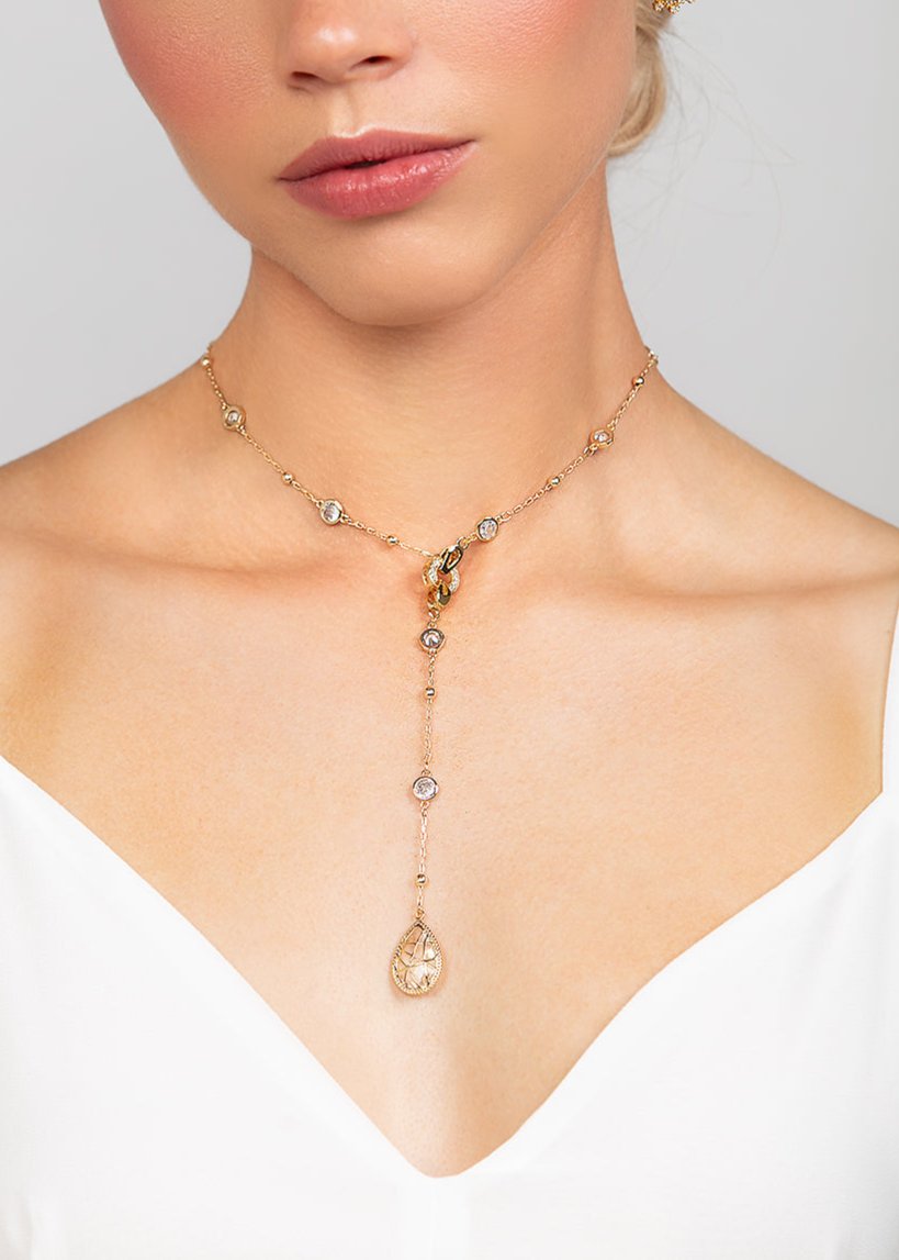 Gold Reed detachable choker and lariat necklace featuring an elegant, crystal chain and design with teardrop crystal drop shown worn in the front.