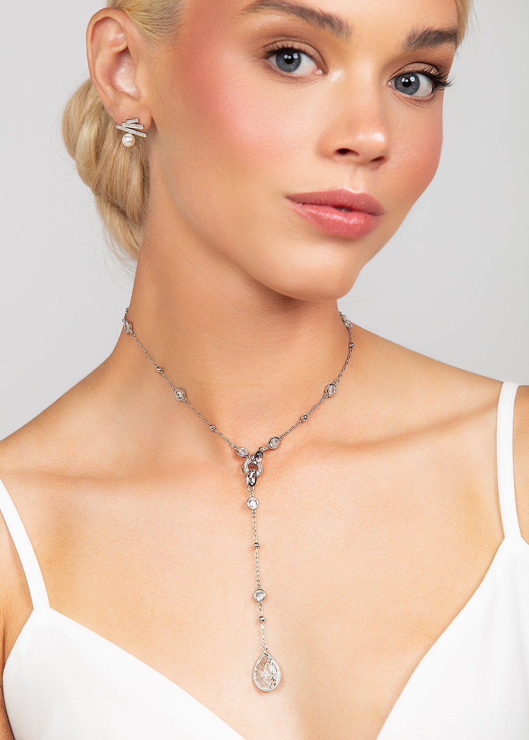 Silver Reed necklace featuring an elegant, modern design with crystal details, paired with Quinn sterling silver triple bar pave crystal post earrings adorned with a 6mm pearl for a sophisticated look.