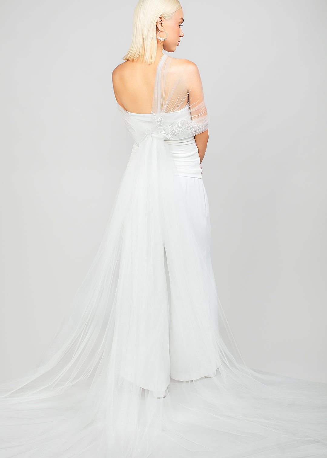 For the bride who wants drama without a veil, this modern tulle wrap with an asymmetrical design and sparkly sequin rose lace applique, adding a dramatic train to bridal looks.