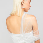 Back detail shot of the Regal modern tulle wrap with an asymmetrical design and sparkly sequin rose lace applique, adding drama to wedding day looks.