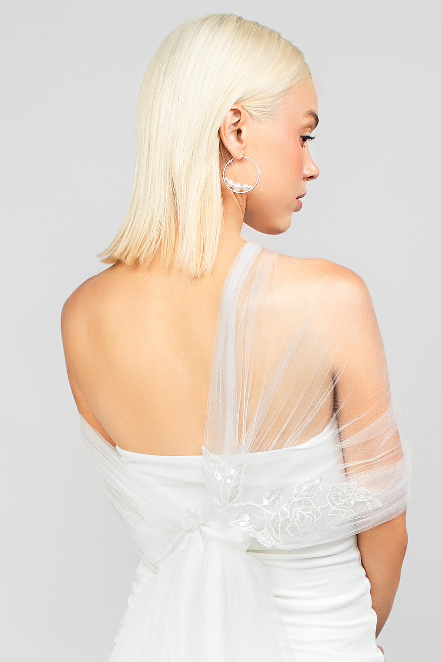 Back detail shot of the Regal modern tulle wrap with an asymmetrical design and sparkly sequin rose lace applique, adding drama to wedding day looks.