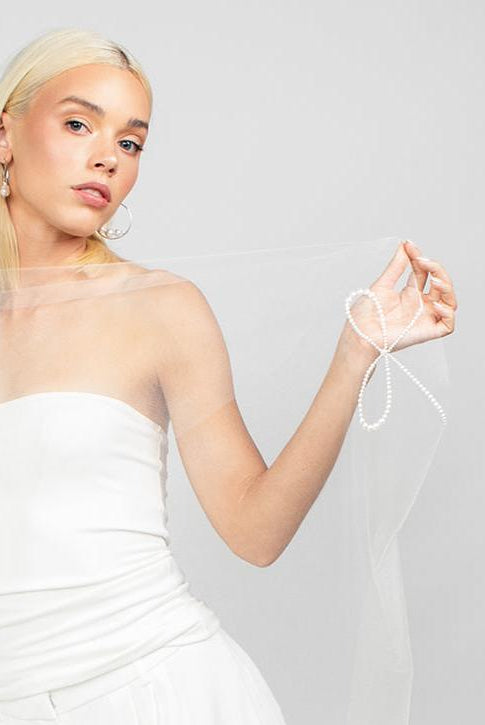 Cathedral-length wedding veil with Austrian pearl bow design along the border of the veil for a modern feminine on trend bridal look detail.