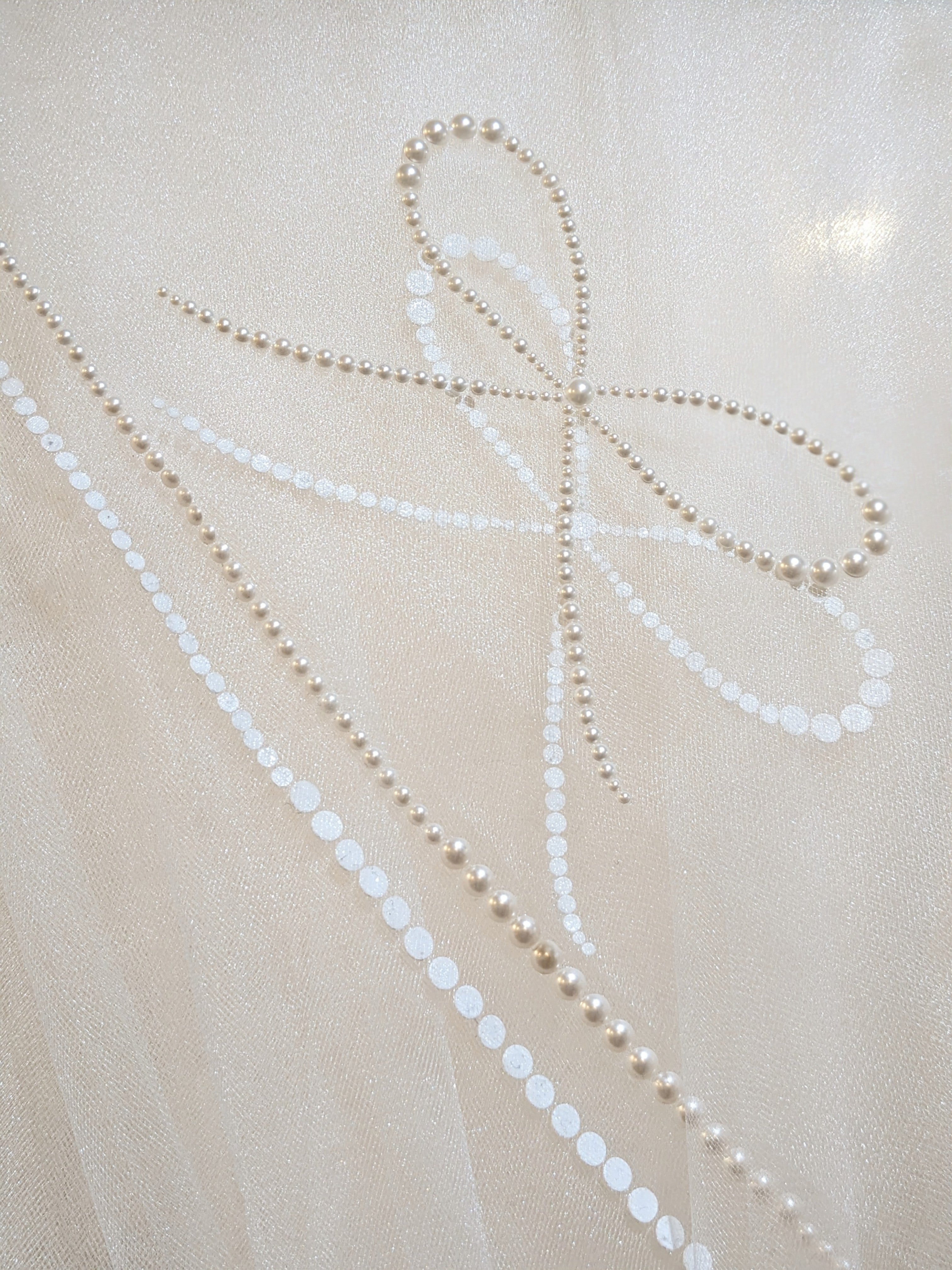 A detail shot of the Austrian pearl detail on the Reign cathedral length wedding veil.