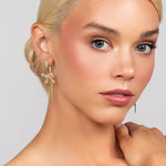 Modern and trendy Riley bow drop earrings shown in gold with a pave crystal and pearl design perfect for the holidays or any festive occassion.