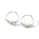 Rhodium-plated hoop earrings featuring Austrian pearls elegantly suspended at the base, creating a chic floating effect, perfect for modern bridal or everyday style.