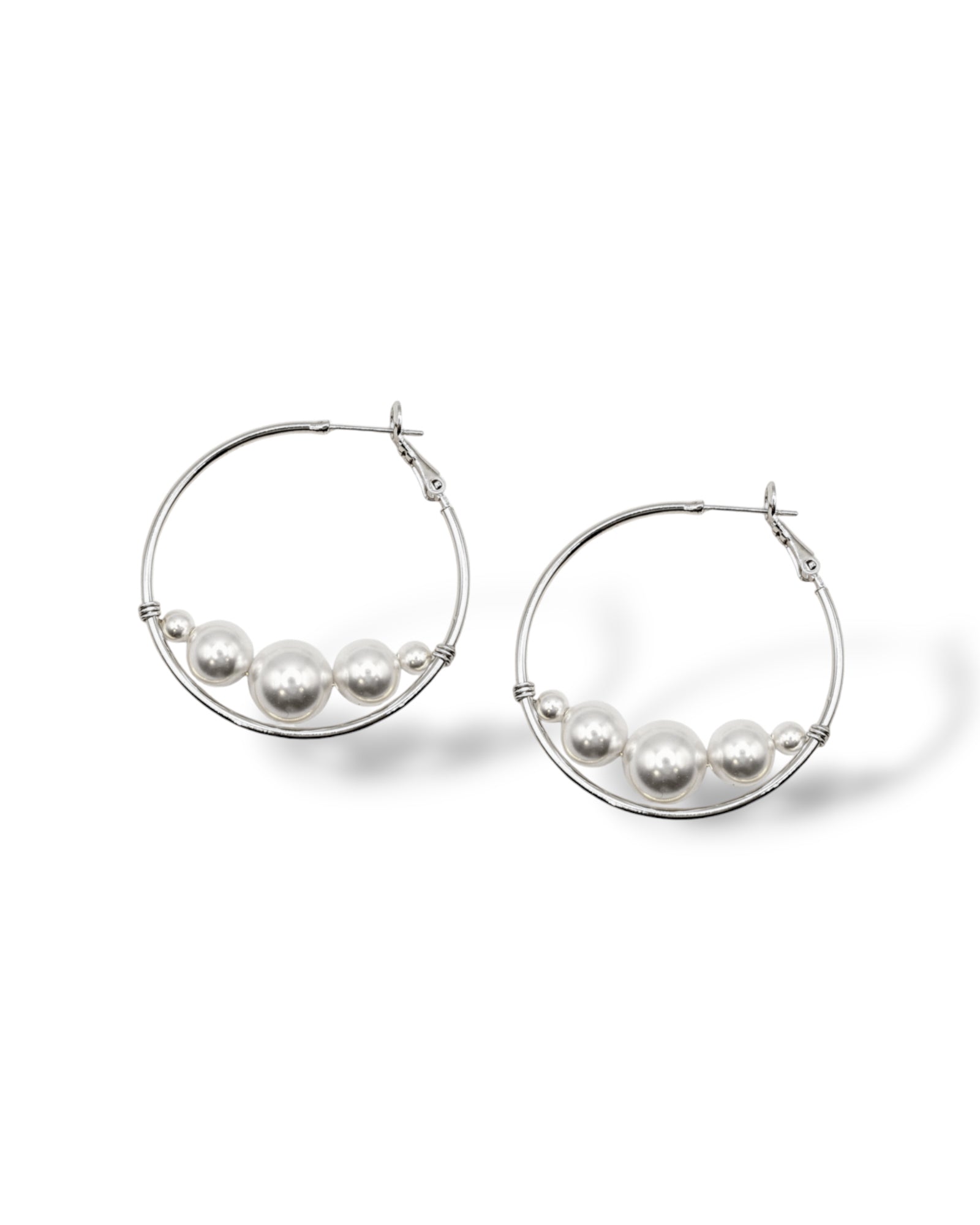 Rhodium-plated hoop earrings featuring Austrian pearls elegantly suspended at the base, creating a chic floating effect, perfect for modern bridal or everyday style.