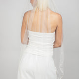 Single-tier oval-cut fingertip-length veil with clusters of Austrian pearls and see-through crystals at the bottom, fading to a light scatter.