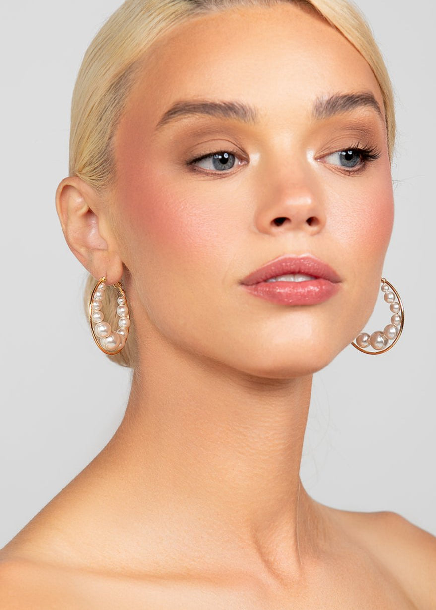 Gold-plated large hoops with floating Austrian pearls, designed for modern and versatile wear.