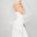 Modern two-tier double-row horsehair trimmed bridal veil with the blusher pulled over the face.