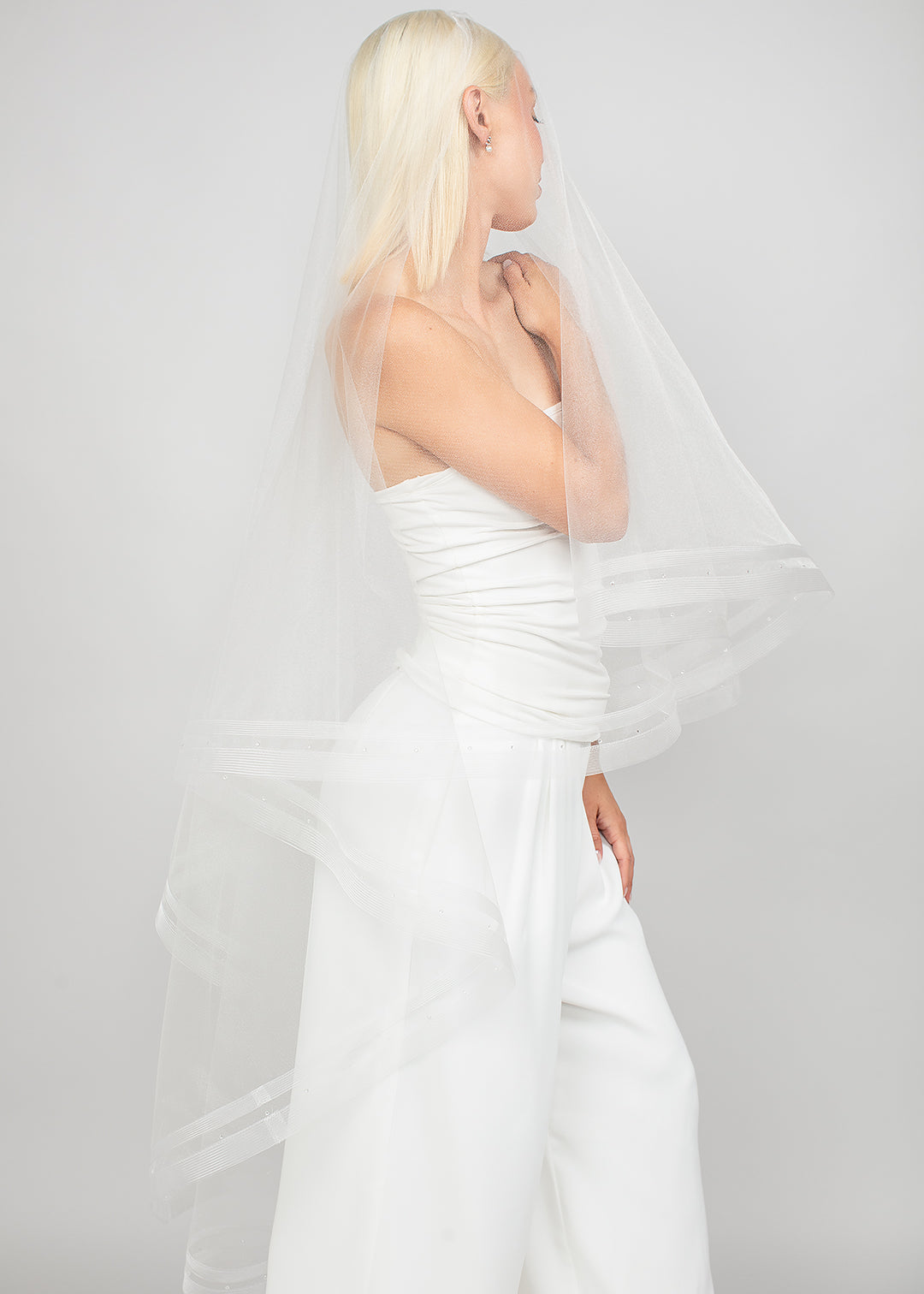 Modern two-tier double-row horsehair trimmed bridal veil with the blusher pulled over the face.