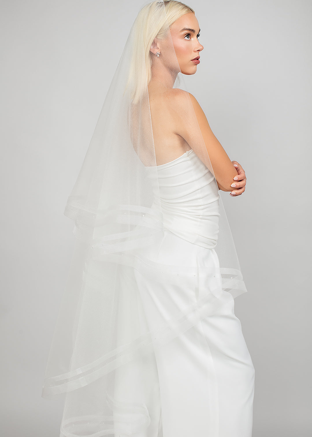 Side view of the 2 tier waltz-length fold over veil with a double row of horsehair trim and scattered Austrian crystals, available in bright white and sparkly light ivory 