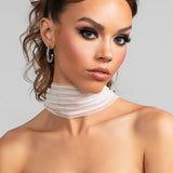 Model wearing the Savannah striped tulle scarf draped around her neck, the front view. Paired with the Sparkle large crystal hoop earrings.
