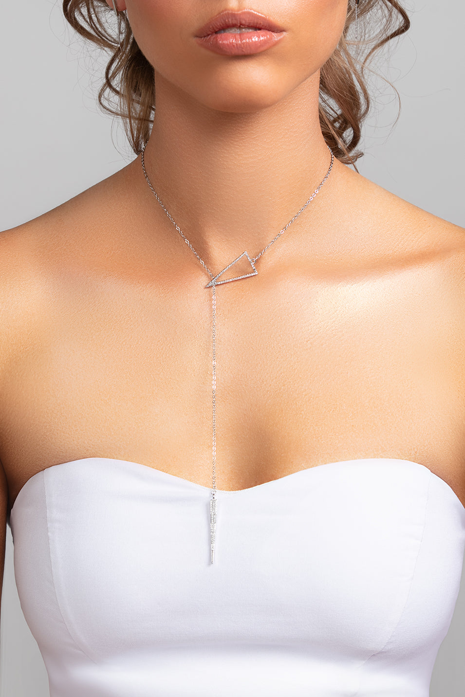 Model wearing Sutton silver lariat spike pave cz crystal necklace styled in the front with strapless dress