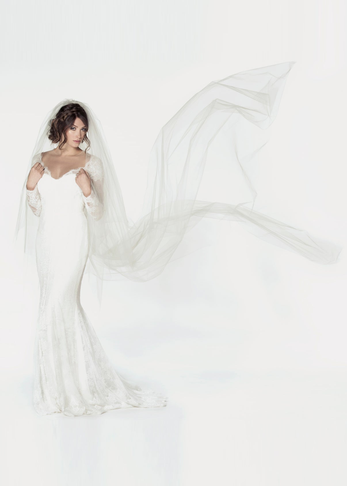 Two tier cathedral length wedding veil with a handkerchief cut, and a clean raw cut edge. Showing the veil flying in the air.